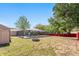 Caged pool and backyard on a sunny day with a fire pit, shed, attractive landscaping, and secure fencing at 5041 Ne 4Th St, Ocala, FL 34470