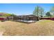 View of the caged pool with a well-manicured yard and attractive landscaping on a sunny day at 5041 Ne 4Th St, Ocala, FL 34470