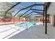 Enclosed pool area featuring a screened enclosure, inground pool with ladders, and concrete pool deck at 5041 Ne 4Th St, Ocala, FL 34470