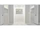 This walk-in closet features a central dressing mirror, and has white tile floors at 5041 Ne 4Th St, Ocala, FL 34470