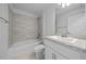 Bathroom vanity, toilet and tub featuring neutral wall tiles and wood-look floors at 5086 Sw 91St St, Ocala, FL 34476