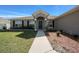 Inviting front entrance with a pathway, complemented by dark shutters and manicured landscaping at 5086 Sw 91St St, Ocala, FL 34476