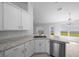 Well-lit kitchen with stainless steel appliances, white cabinets, and granite countertops at 5086 Sw 91St St, Ocala, FL 34476