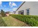 Well-maintained backyard with privacy hedge, green grass, and view of the home's exterior at 5563 Nw 40Th Pl, Ocala, FL 34482