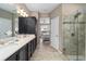 Bathroom with double sinks, walk-in shower, and view into Primary bedroom at 5563 Nw 40Th Pl, Ocala, FL 34482