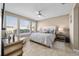 Inviting bedroom with large windows, ceiling fan, and comfortable bed with decorative pillows at 5563 Nw 40Th Pl, Ocala, FL 34482