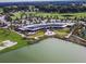 Stunning aerial view of the grand clubhouse overlooking a serene lake and lush green golf course at 5563 Nw 40Th Pl, Ocala, FL 34482