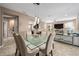 Open-concept dining room with a glass-top table, modern chandelier, and seamless access to the living area at 5563 Nw 40Th Pl, Ocala, FL 34482