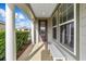 Charming covered front porch showcases white columns and a cozy bench for welcoming guests at 5563 Nw 40Th Pl, Ocala, FL 34482