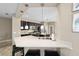 Gourmet kitchen featuring black cabinets, quartz counters, and pendant lighting above the breakfast bar seating at 5563 Nw 40Th Pl, Ocala, FL 34482