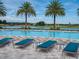 Relaxing pool deck featuring comfortable lounge chairs, and a view of the adjacent lake at 5563 Nw 40Th Pl, Ocala, FL 34482