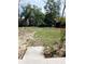 A large, sunny backyard with established lawn, landscaping, and wooded perimeter at 5860 Sw 64Th Street Rd, Ocala, FL 34474