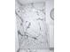 Marble-look tiled shower with a river rock floor and a shower head at 5860 Sw 64Th Street Rd, Ocala, FL 34474
