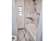 Bathroom with a tub and tiled marble-look walls and floors at 5860 Sw 64Th Street Rd, Ocala, FL 34474