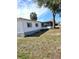 Exterior angle view of the home featuring neutral paint, a screened lanai, and established lawn at 5860 Sw 64Th Street Rd, Ocala, FL 34474