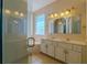 Bathroom with double sinks, marble countertops, glass shower, and soaking tub at 5916 Nw 27Th Pl, Ocala, FL 34482