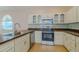 Charming kitchen featuring white cabinets, stainless steel appliances, and tile flooring at 5916 Nw 27Th Pl, Ocala, FL 34482