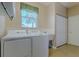 Laundry room with white washer, dryer, utility sink, and a window at 5916 Nw 27Th Pl, Ocala, FL 34482