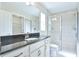 Modern bathroom featuring granite countertops, white cabinets, and glass-enclosed shower at 6047 Sw 128Th Street Rd, Ocala, FL 34473