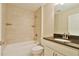Cozy tiled bathroom with shower/tub combo, neutral paint, and dark granite countertop at 6047 Sw 128Th Street Rd, Ocala, FL 34473