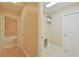 Hallway view to laundry room with closet and tiled bath/shower combo with tan ceramic tile surround at 6047 Sw 128Th Street Rd, Ocala, FL 34473