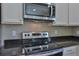 Modern kitchen features stainless steel appliances, granite countertops, and white cabinetry at 6047 Sw 128Th Street Rd, Ocala, FL 34473
