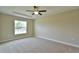 Spacious carpeted main bedroom featuring a tray ceiling and a large window at 6047 Sw 128Th Street Rd, Ocala, FL 34473