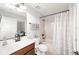 Well-lit bathroom featuring a tub with stylish shower curtain and vanity with granite countertops at 6125 Se 11Th St, Ocala, FL 34472