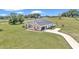Lovely aerial view of a beautiful home and backyard featuring lush landscaping, a driveway, and a playground at 7432 Ne 26Th Ave, Ocala, FL 34479