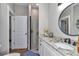 Well-lit bathroom featuring a walk-in shower, granite countertop and a round mirror at 7432 Ne 26Th Ave, Ocala, FL 34479