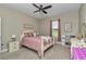 Bedroom featuring a ceiling fan, window with curtains, neutral walls and a bed with pink bedding at 7432 Ne 26Th Ave, Ocala, FL 34479