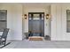Elegant front door with glass panels and sidelights, complemented by stylish lighting fixtures and plants at 7432 Ne 26Th Ave, Ocala, FL 34479