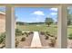 Inviting view through the porch columns of a lush green lawn, landscaping, and neighboring farmland at 7432 Ne 26Th Ave, Ocala, FL 34479