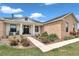 Close up of the inviting home with a brick facade, rocking chairs, and a well-manicured lawn at 7432 Ne 26Th Ave, Ocala, FL 34479