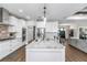 Bright kitchen with granite island and bar stools, white cabinetry, and stainless appliances at 7432 Ne 26Th Ave, Ocala, FL 34479
