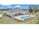 Backyard features a pool with lounge chairs, outdoor kitchen area and covered porch at 7432 Ne 26Th Ave, Ocala, FL 34479