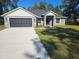 Beautiful single-story home with a well-manicured lawn, concrete driveway, and attached two-car garage at 7677 Sw 81St Pl, Ocala, FL 34476