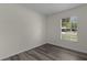 Bedroom with a window view, wood floors, and light-colored walls at 9607 Se 122Nd Pl, Belleview, FL 34420