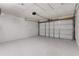 This garage features a painted floor, white painted walls, and a white garage door at 9607 Se 122Nd Pl, Belleview, FL 34420