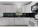Bright kitchen with white cabinetry, modern appliances, and attractive tiled backsplash at 9607 Se 122Nd Pl, Belleview, FL 34420