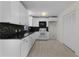 Well-lit kitchen with white cabinets, black countertops, and decorative mosaic backsplash at 9607 Se 122Nd Pl, Belleview, FL 34420