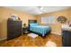 Comfortable bedroom featuring unique flooring, a ceiling fan, and ample natural light from the window at 9770 Sw 97Th Pl, Ocala, FL 34481