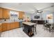 Open kitchen with wooden cabinets, island with seating, stainless steel appliances, and a tile floor at 9770 Sw 97Th Pl, Ocala, FL 34481