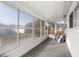 A view of the screened-in porch with gray flooring and ladder leaned against the wall at 9770 Sw 97Th Pl, Ocala, FL 34481
