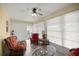 Bright sunroom with rattan furniture, ceiling fan, and large windows with blinds at 9770 Sw 97Th Pl, Ocala, FL 34481