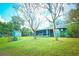 Spacious backyard with a lush lawn, a screened-in porch, mature trees and a storage shed offers privacy and tranquility at 9795 Ne 303Rd Ave, Salt Springs, FL 32134