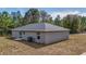 Rear view of the new construction house showing siding, windows, lawn, and HVAC system at 10069 Sw 140Th Ave, Dunnellon, FL 34432