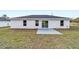 New construction backyard with a small concrete patio and sliding glass doors at 13395 Sw 106 St, Dunnellon, FL 34432