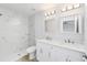 Bright bathroom featuring double vanity, modern fixtures, and a walk-in shower with elegant marble-style tile at 13395 Sw 106 St, Dunnellon, FL 34432