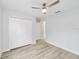Bright bedroom with wood-look flooring, ceiling fan, and closet with paneled doors at 13395 Sw 106 St, Dunnellon, FL 34432
